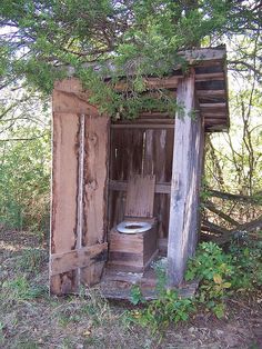 an old outhouse with a toilet in it