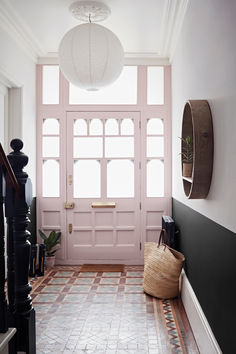 an entryway with a pink door and tiled floor