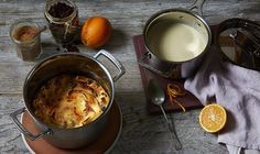 a table topped with pots and pans filled with food next to an orange slice