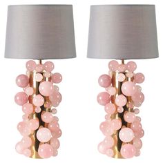 two lamps with pink balls on them are next to each other