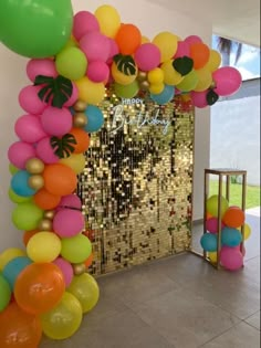 an arch made out of balloons and confetti on the wall in front of a door