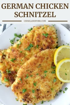 two chicken schnitzel on a white plate with lemons and parsley