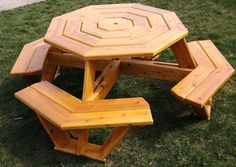 a wooden picnic table and benches in the grass