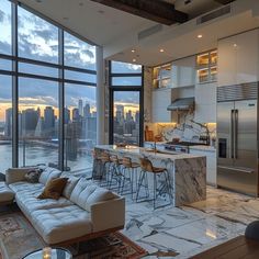 a living room filled with furniture and large windows overlooking a cityscape at sunset