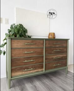 a wooden dresser with drawers and plants on top