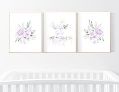 three floral prints on the wall above a crib