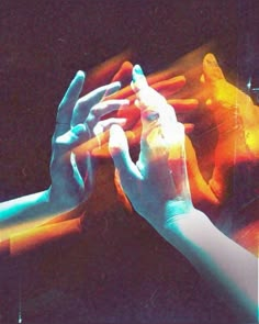 two hands reaching out towards each other in front of a television screen with colored lights on it