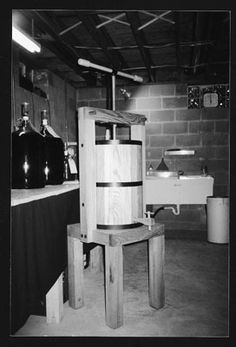 a black and white photo of a room with a sink, toilet and wooden chair