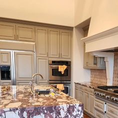 a kitchen with marble counter tops and stainless steel appliances