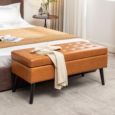 a bed with a brown ottoman sitting on top of it