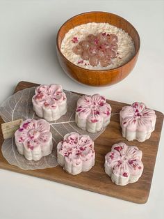 small desserts are arranged on a wooden tray next to a bowl of ice cream