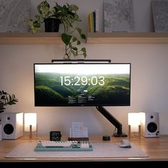 a computer monitor sitting on top of a wooden desk next to speakers and a keyboard