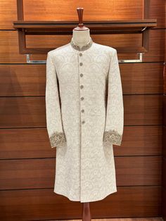 With this gorgeous white embroidered sherwani for men, you can really make a statement on your wedding day! It's a work of art! Beautiful embroidered floral patterns adorn the karandi base, and the ban and cuffs are embellished with hand-stitched zardozi designs. Various zari materials ensure a regal appearance by balancing the color scheme. At [Your Shop Name], we provide a made-to-measure experience while placing a premium on quality. For the ideal fit, be prepared for a measurement form and a Semi-stitched White Nehru Jacket For Wedding, Cream Sherwani For Groom Eid Festival, Cream Sherwani For Groom At Eid, Cream Sherwani For Groom Eid Celebration, Cream Sherwani With Zari Work For Groom, Fitted Sherwani With Chikankari Embroidery For Groom, Fitted Chikankari Embroidery Sherwani For Groom, Fitted Sherwani With Dabka For Wedding, White Nehru Jacket For Groom With Traditional Drape