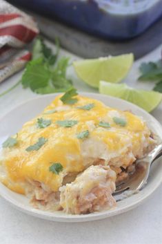 a white plate topped with an enchilada covered in cheese and cilantro