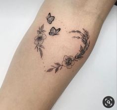 a woman's arm with flowers and butterflies on it in the shape of a heart