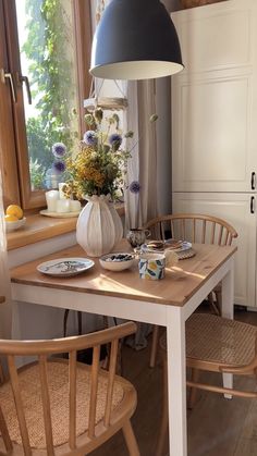 a dining room table with plates and flowers on it