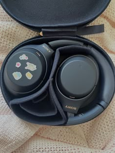 two black headphones sitting in an open case