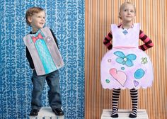 two children in costumes standing on stools