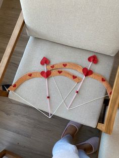 someone is working on something that looks like a bow and arrow with hearts attached to it