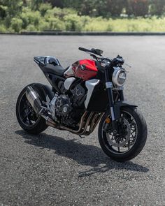 a red and black motorcycle parked on the street