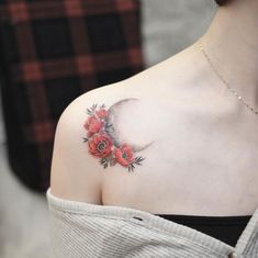 a woman's shoulder with flowers and a half moon tattoo on her left shoulder