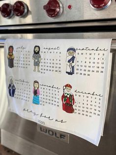 a calendar is hanging on the front of an oven with stickers attached to it