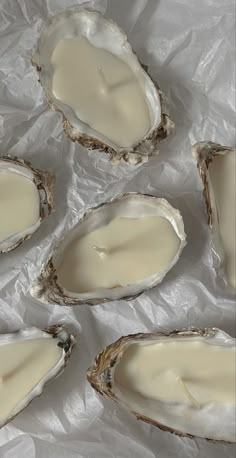 six oysters are sitting on wax paper