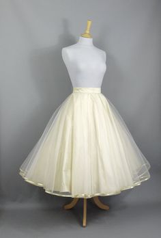 "This show stopping bridal skirt is made from a layer of Champagne Silk Dupion and a layer of ivory tulle hemmed in Gold trim. The tulle layer is a double circle which means lots and lots of volume! Wear with a 'Swing' petticoat for extra swish on the dance floor (or seen in the last photo without a petticoat underneath) and choose your length to create a unique outfit for your special day. This over-skirt can be made in a range of standard sizes or can be made to fit your exact waist measuremen Gold Champagne Bridesmaid Skirt, Double Citcle Skirt, Champagne Wedding Skirt, Organza Wedding Skirt With Attached Cancan, Wedding Tea Length Dress With Tulle Skirt, Organza Wedding Dress With Full Skirt, Organza Full Skirt Wedding Dress, Voluminous Wedding Skirt With Attached Cancan, Wedding Skirt With Attached Cancan