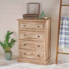 a wooden dresser sitting next to a potted plant