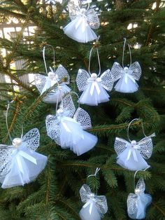 white angel ornaments hanging from a christmas tree