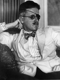 an old photo of a man wearing glasses and a bow tie sitting in a chair