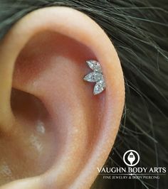 a close up of a person's ear with a small diamond bow on it