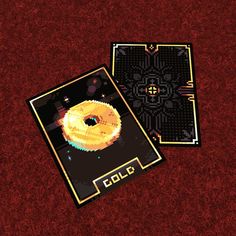 two pieces of pixel art on a red surface with the word colo in gold