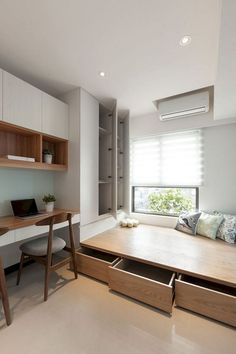 a room with a bed, desk and shelves on the wall next to a window