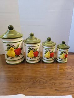 four canisters with fruit painted on them