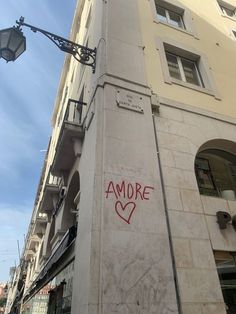 graffiti is spray painted on the side of a building in an alleyway near a street light