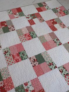 a red and green patchwork quilt on the floor