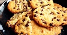 several chocolate chip cookies on a black plate