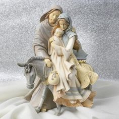 a figurine of a man and woman riding a horse on a white cloth