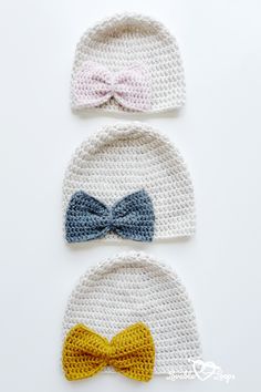 three crocheted hats with bows on them