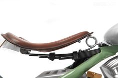 an old motorcycle with a helmet on the handlebars is parked in front of a white background