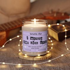 a candle sitting on top of a table next to a string of lights and a guitar