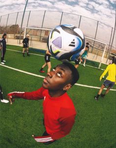 a young man is playing soccer on the field