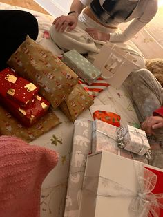 a woman sitting on the floor surrounded by presents