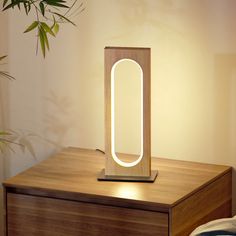 a wooden table with a mirror on it and a plant in the corner next to it