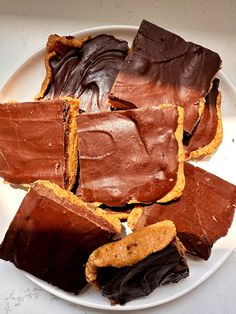 a white plate topped with cut up pieces of chocolate and peanut butter bars on top of each other