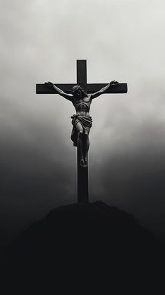 a black and white photo of jesus on the cross with dark clouds in the background