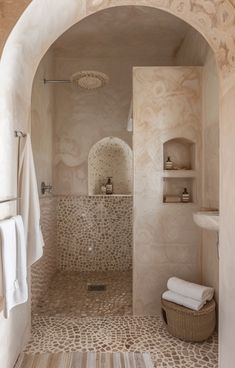 a bathroom with an archway leading into the shower