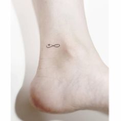 a small tattoo on the foot of a woman's left foot with an infinite symbol