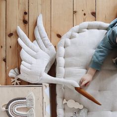 a baby laying on top of a bed next to a stork and other toys